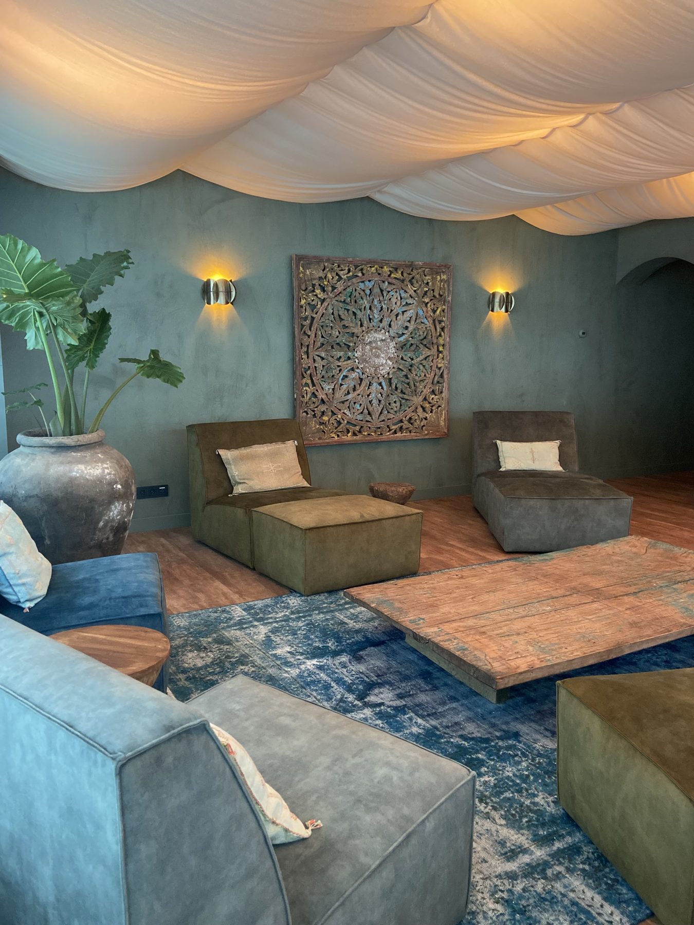 Loungeruimte met betonlook-wanden in groentinten