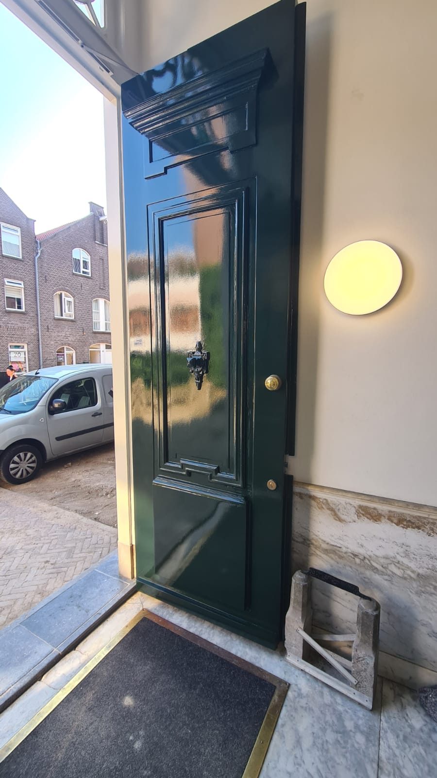 Klassieke voordeur in hoogglans donkergroen na renovatie